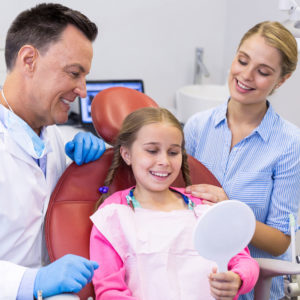 Young patient looking at mirror in dental clinic